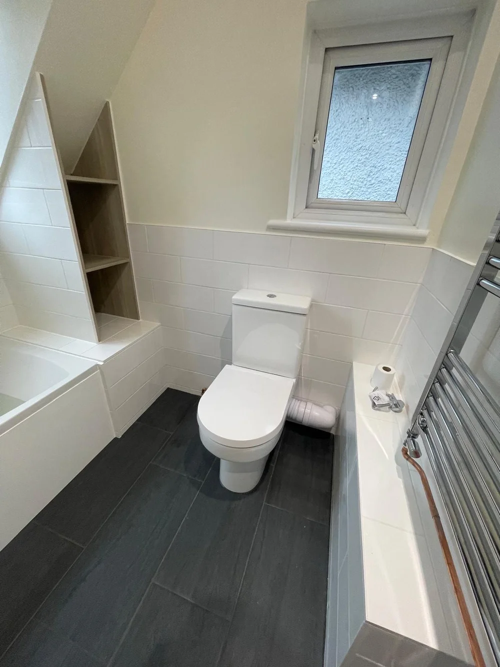 Loft bathroom with metro tiles, bespoke oak shelving and slate floor — bathroom installers in Sunningdale