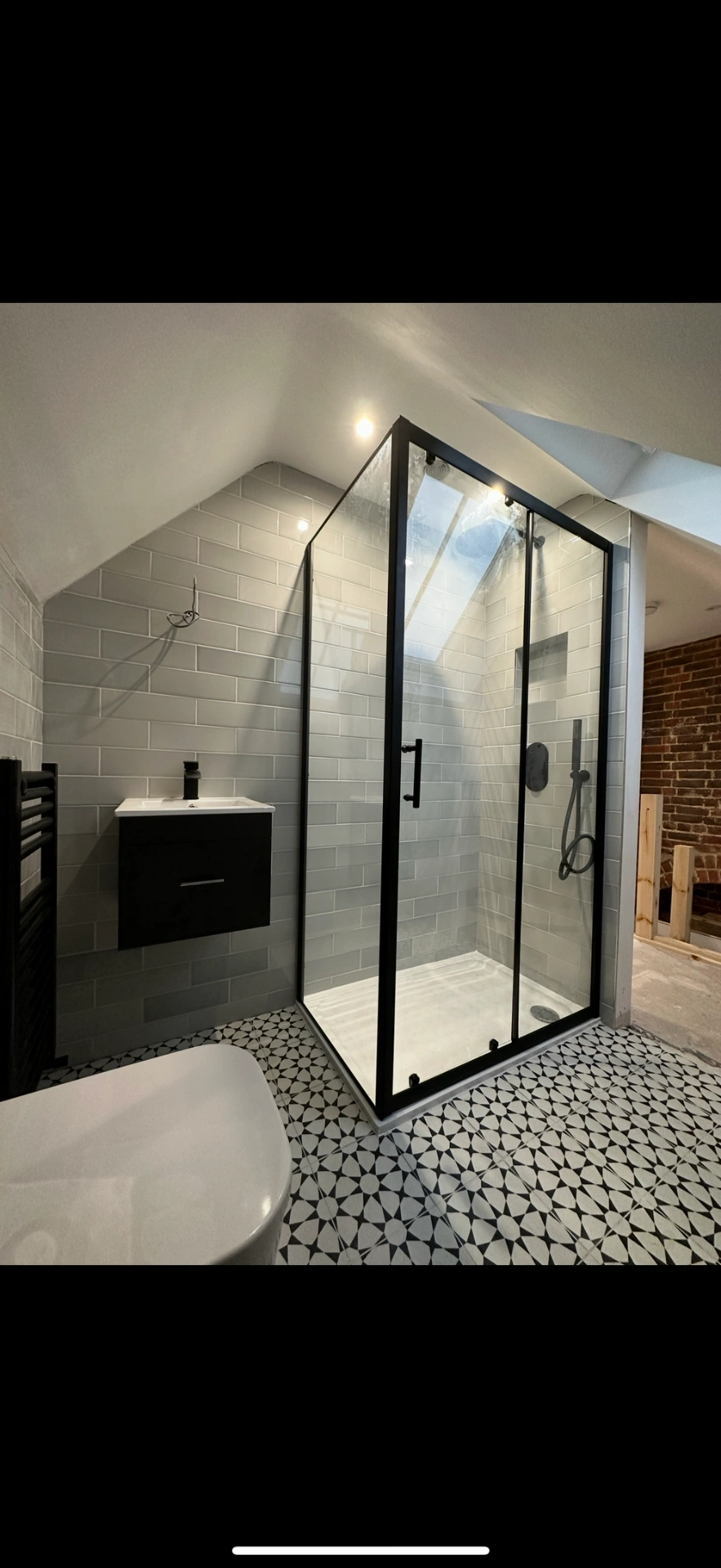 Loft ensuite with matte-black framed shower enclosure and patterned floor — Sunningdale, Berkshire