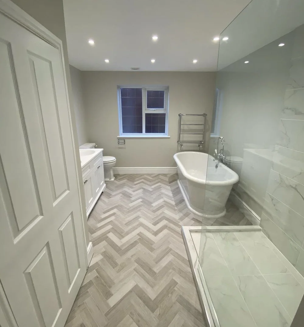 Traditional family bathroom with freestanding roll-top bath, herringbone floor and marble walk-in shower — bathroom installation in Sunningdale