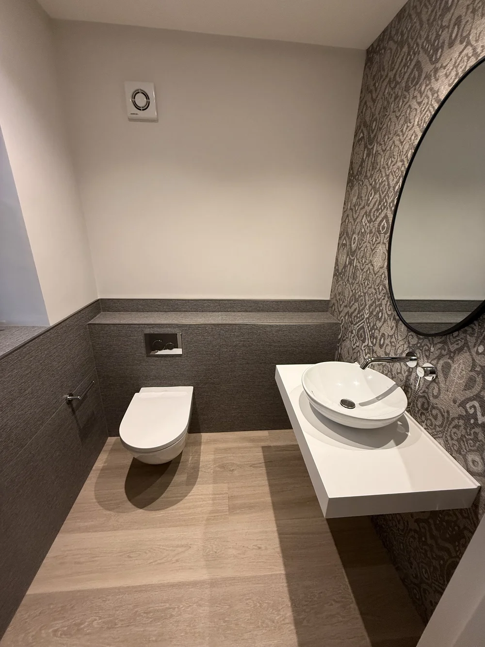 Bespoke cloakroom with patterned wallpaper, oak floor and floating vessel basin — Sunningdale, Berkshire