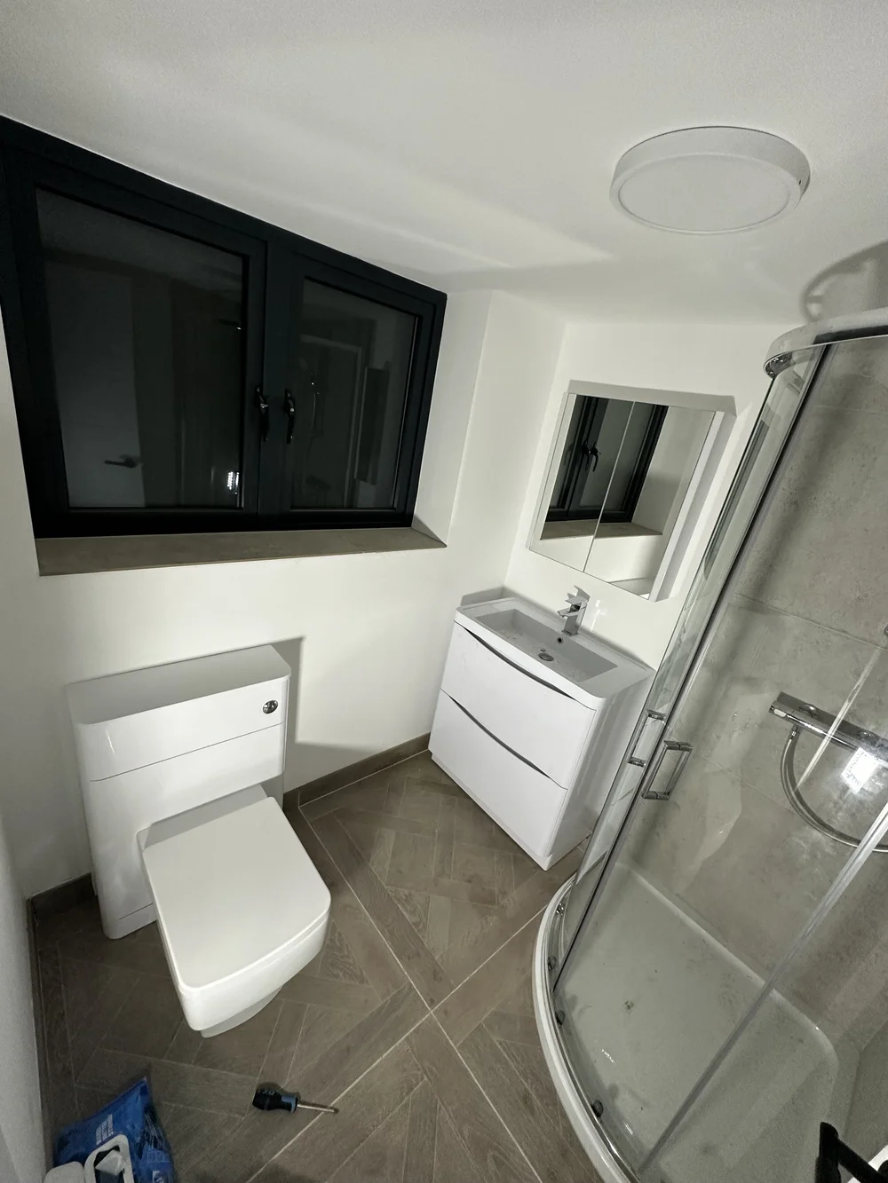 Compact ensuite with quadrant shower enclosure, wall-hung vanity and back-to-wall WC — bathroom installation in Sunningdale